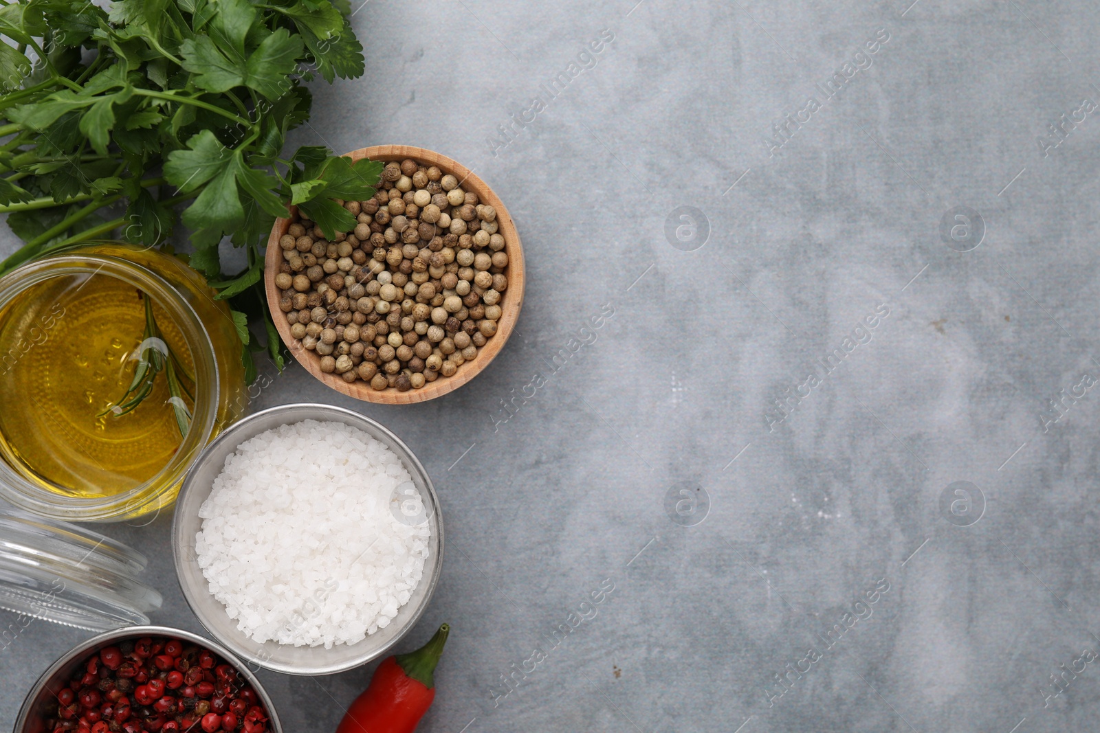 Photo of Aromatic peppercorns and different fresh ingredients for marinade on grey table, flat lay. Space for text