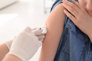 Doctor vaccinating little girl in hospital