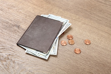 Photo of Pension certificate with American money on brown wooden background