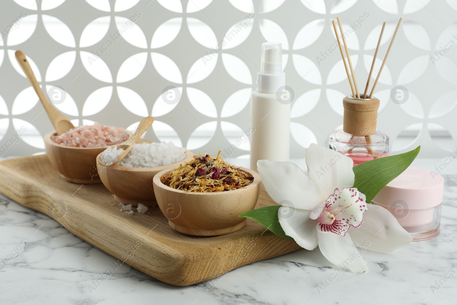 Photo of Beautiful composition with different spa products and orchid on white marble table