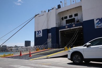 PIRAEUS, GREECE - MAY 19, 2022: Picturesque view of port with Blue Star ferry and car on sunny day