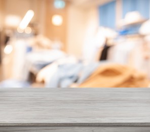 Image of Empty white wooden surface and blurred view of clothes store interior. Space for design