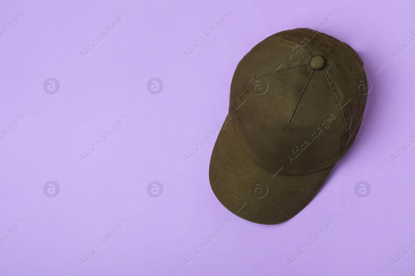 Photo of Baseball cap on violet background, top view. Space for text