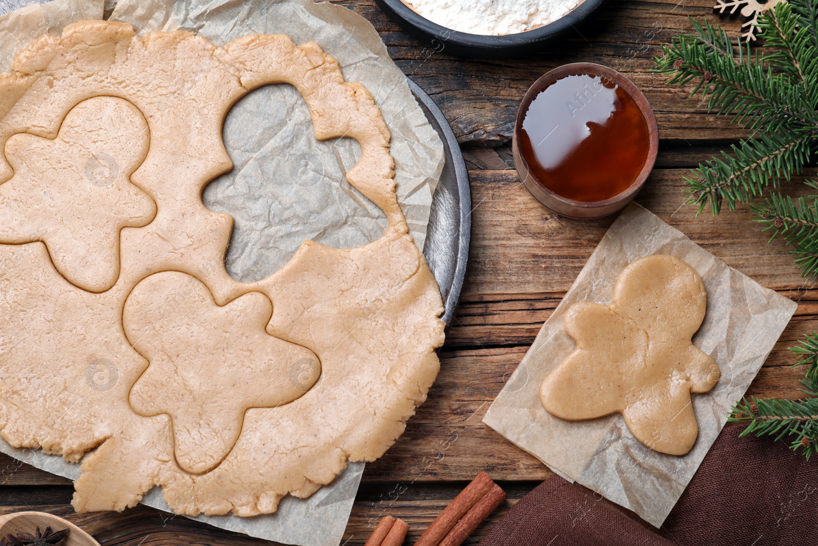 Photo of Flat lay composition with homemade gingerbread man cookies on wooden table