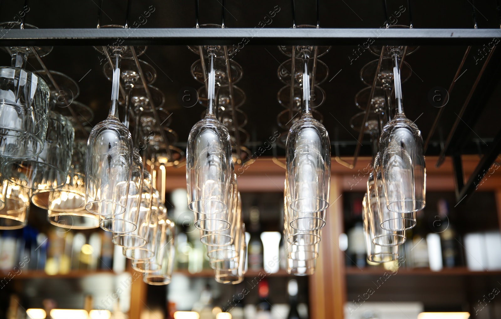 Photo of Many clean glasses on metal rack in restaurant