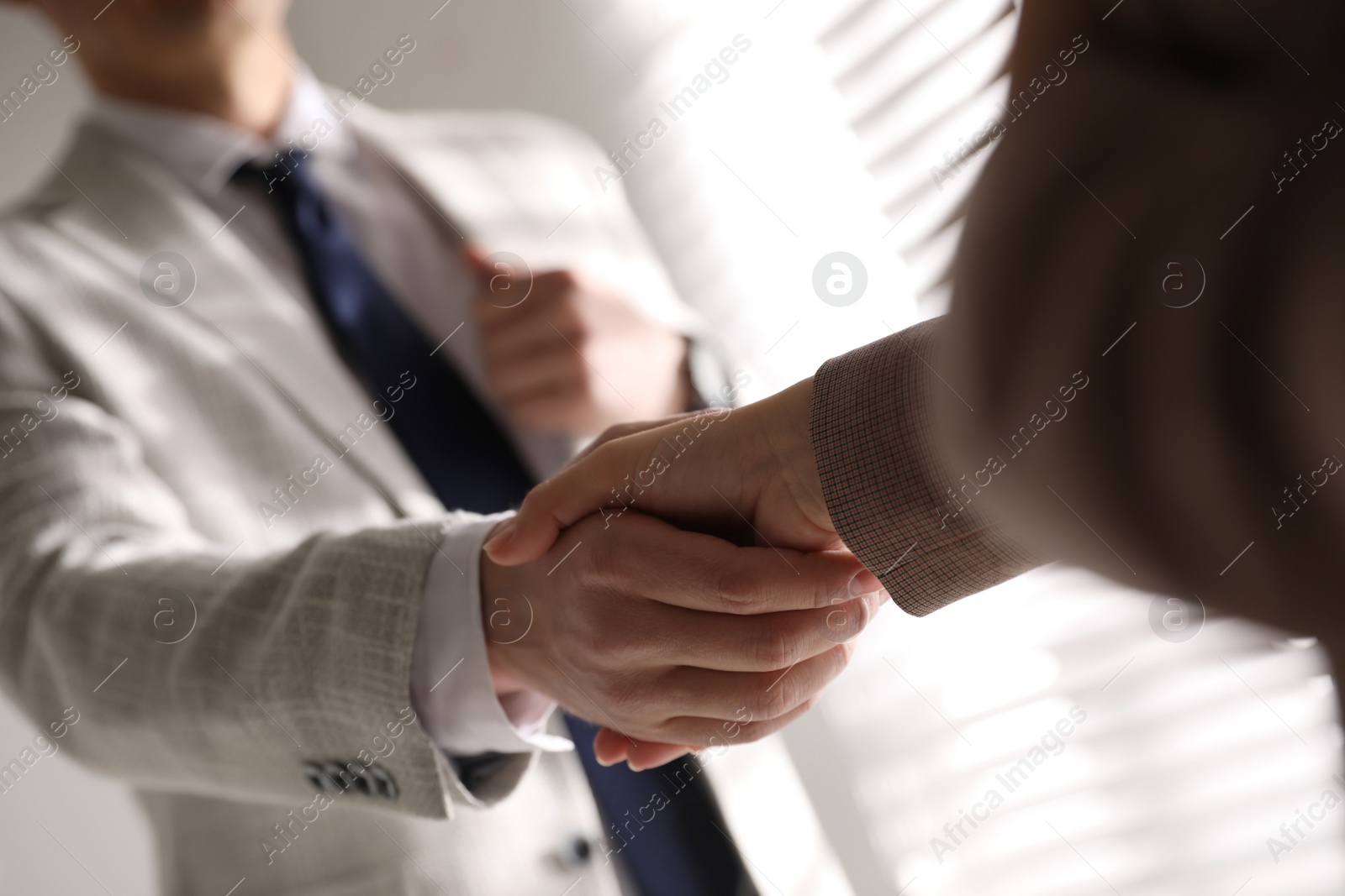 Photo of Business people shaking hands in office, closeup