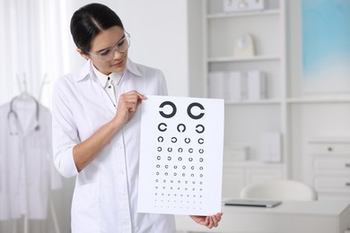 Photo of Ophthalmologist with vision test chart in clinic, space for text