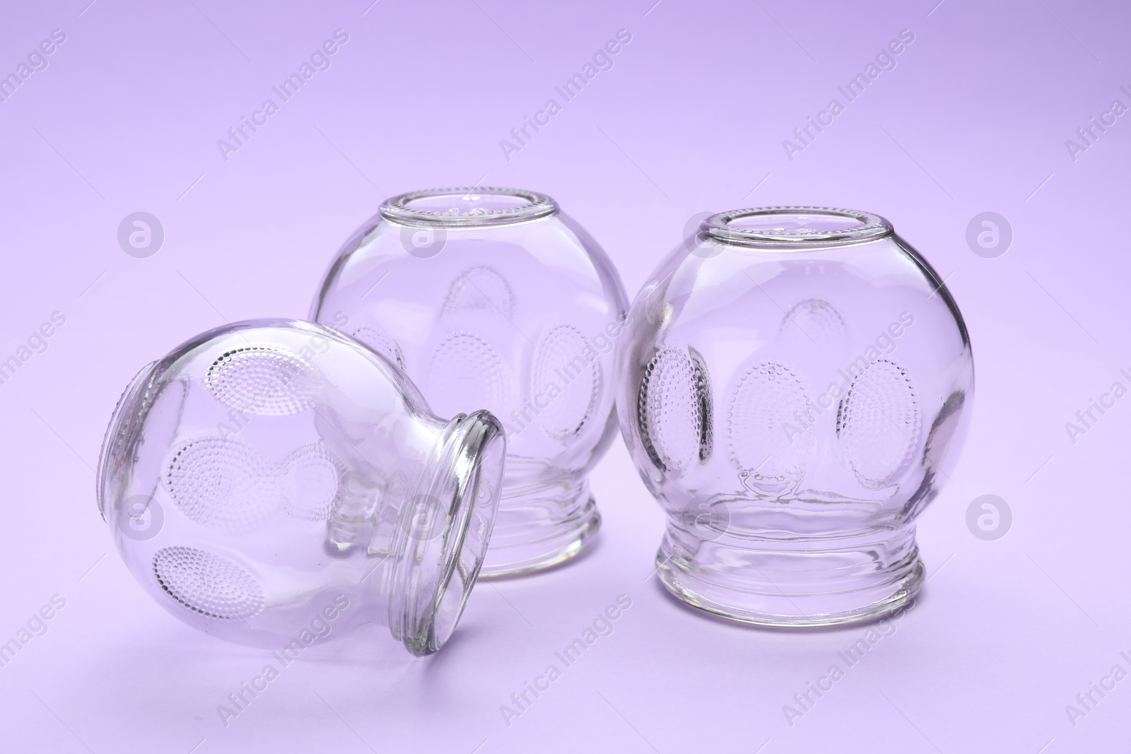 Photo of Glass cups on violet background. Cupping therapy