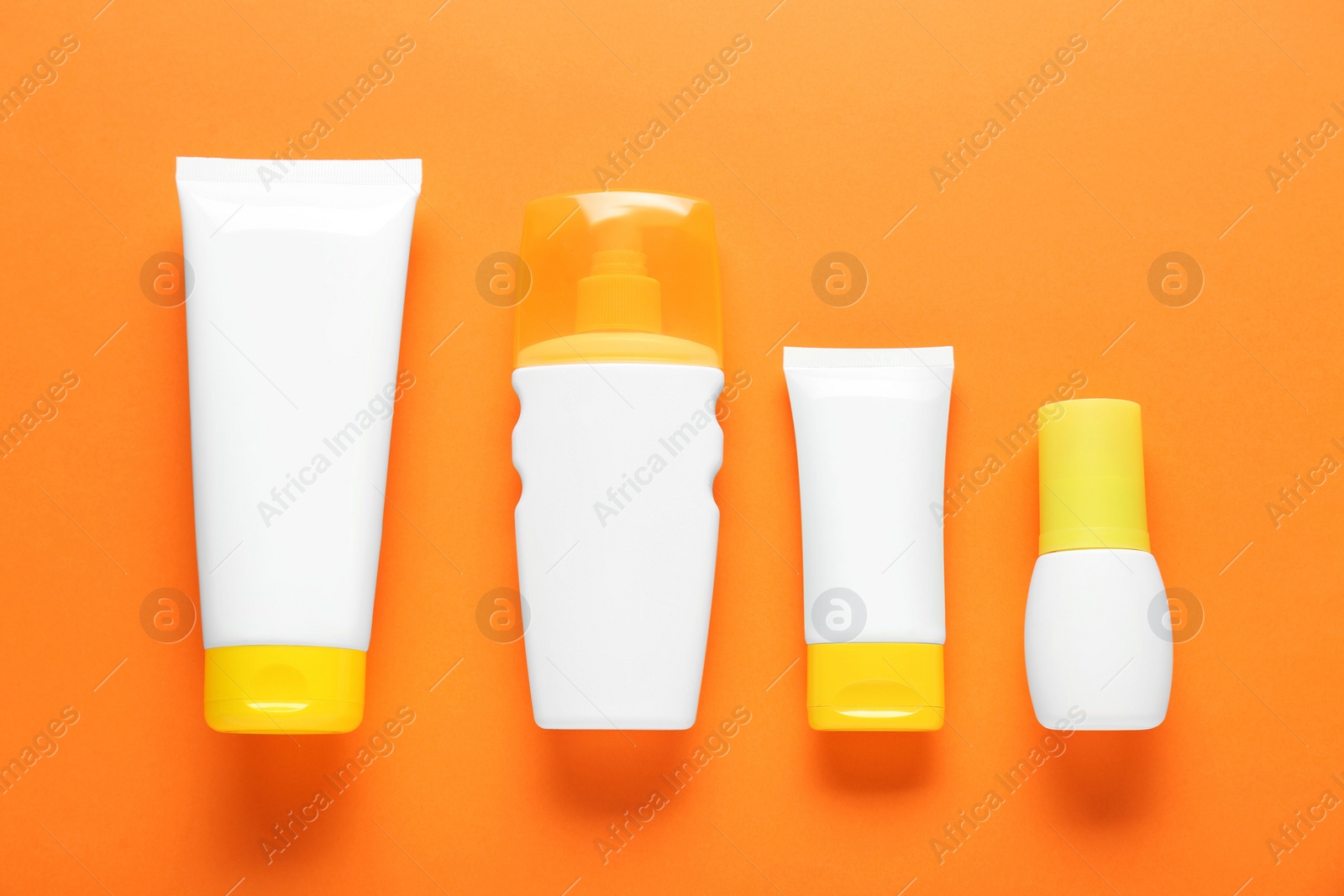 Photo of Suntan products on orange background, flat lay