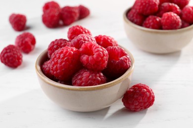 Photo of Tasty ripe raspberries on white table, closeup