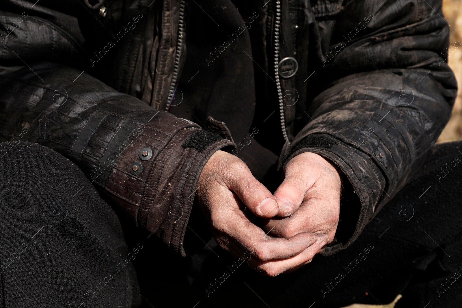 Photo of Poor homeless man with dirty hands outdoors, closeup