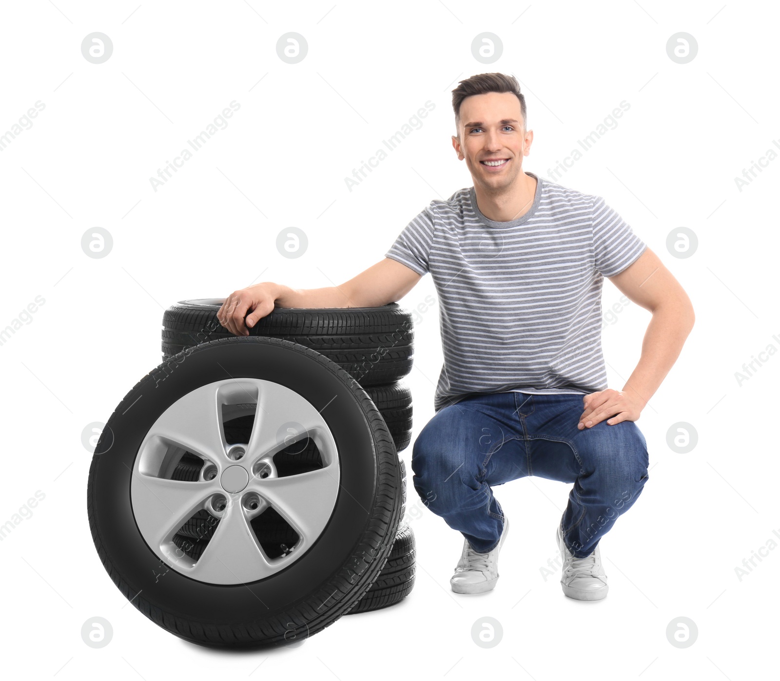 Photo of Young man with car tires on white background