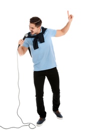 Photo of Young handsome man in casual clothes singing with microphone on white background