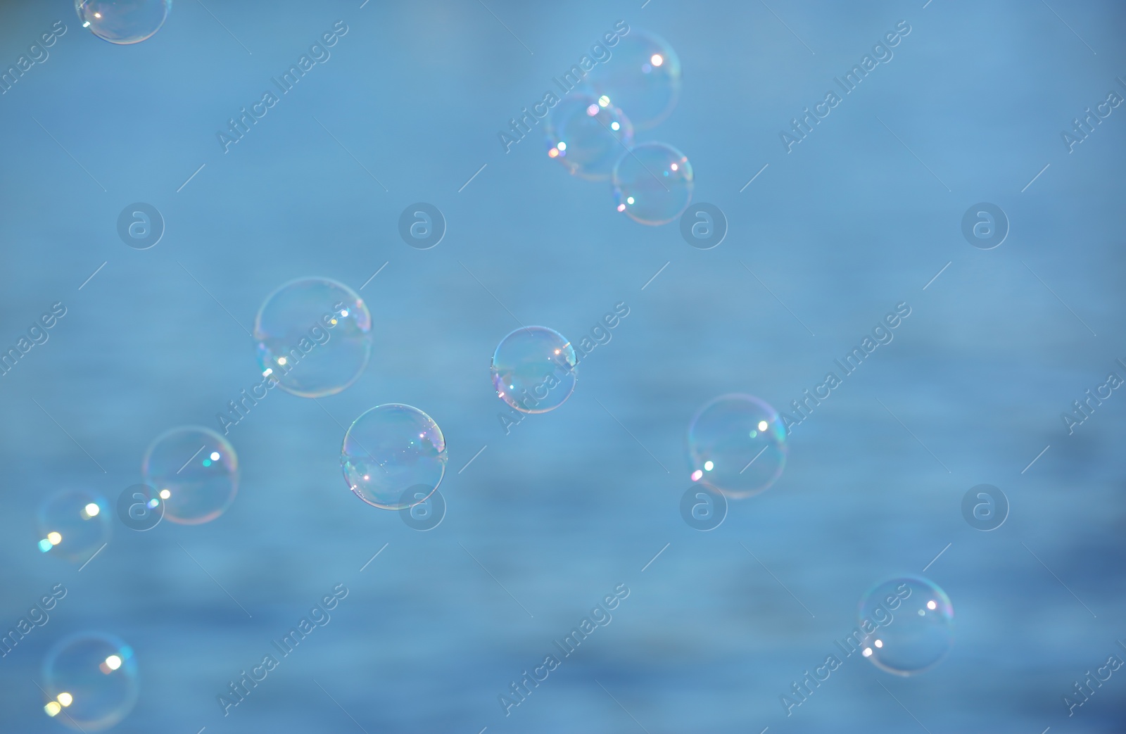 Photo of Beautiful translucent soap bubbles outdoors on sunny day