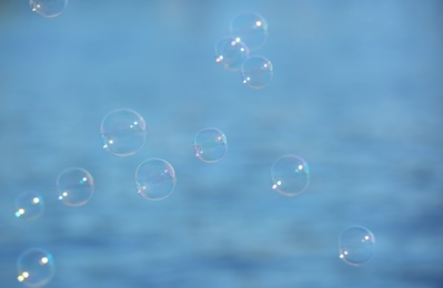 Photo of Beautiful translucent soap bubbles outdoors on sunny day