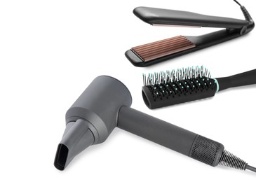 Hair dryer, straightener and brush on white background