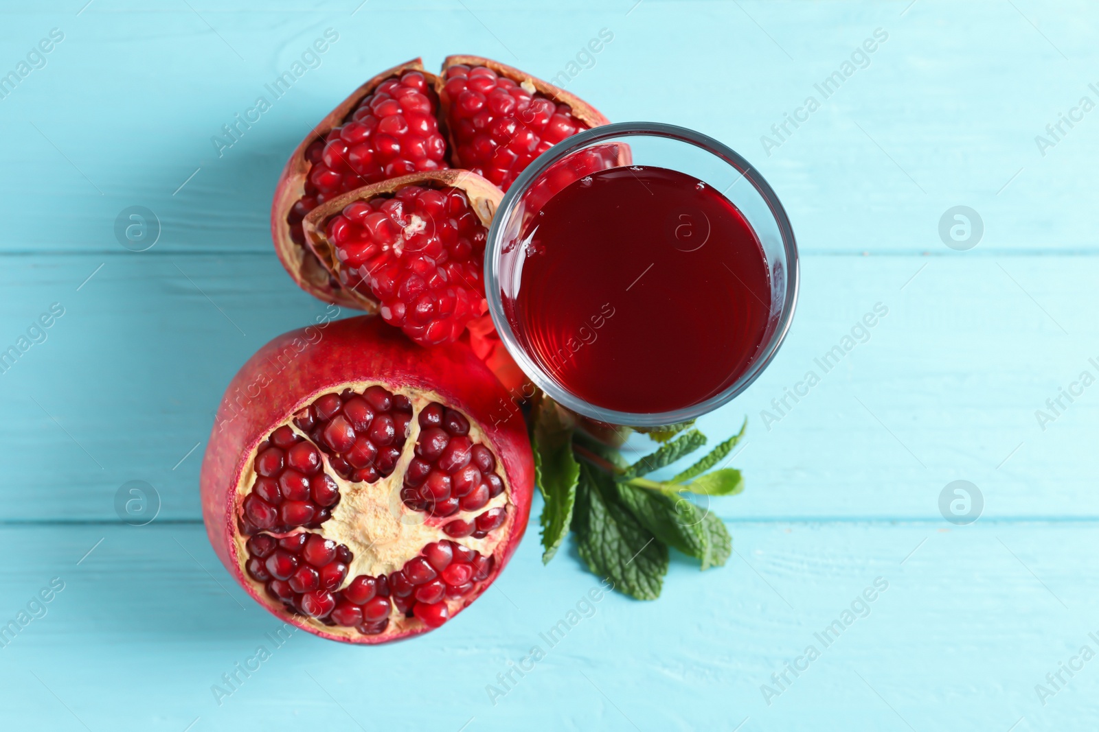 Photo of Glass of pomegranate juice and fresh fruits on wooden background, top view