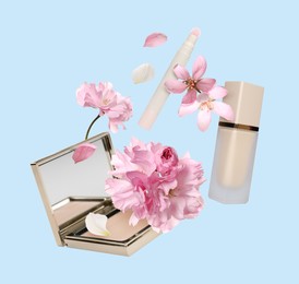 Image of Spring flowers and makeup products in air on light blue background