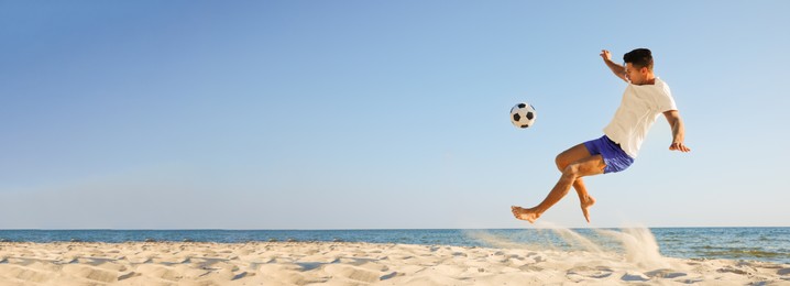Image of Man playing football on sandy beach, space for text. Banner design