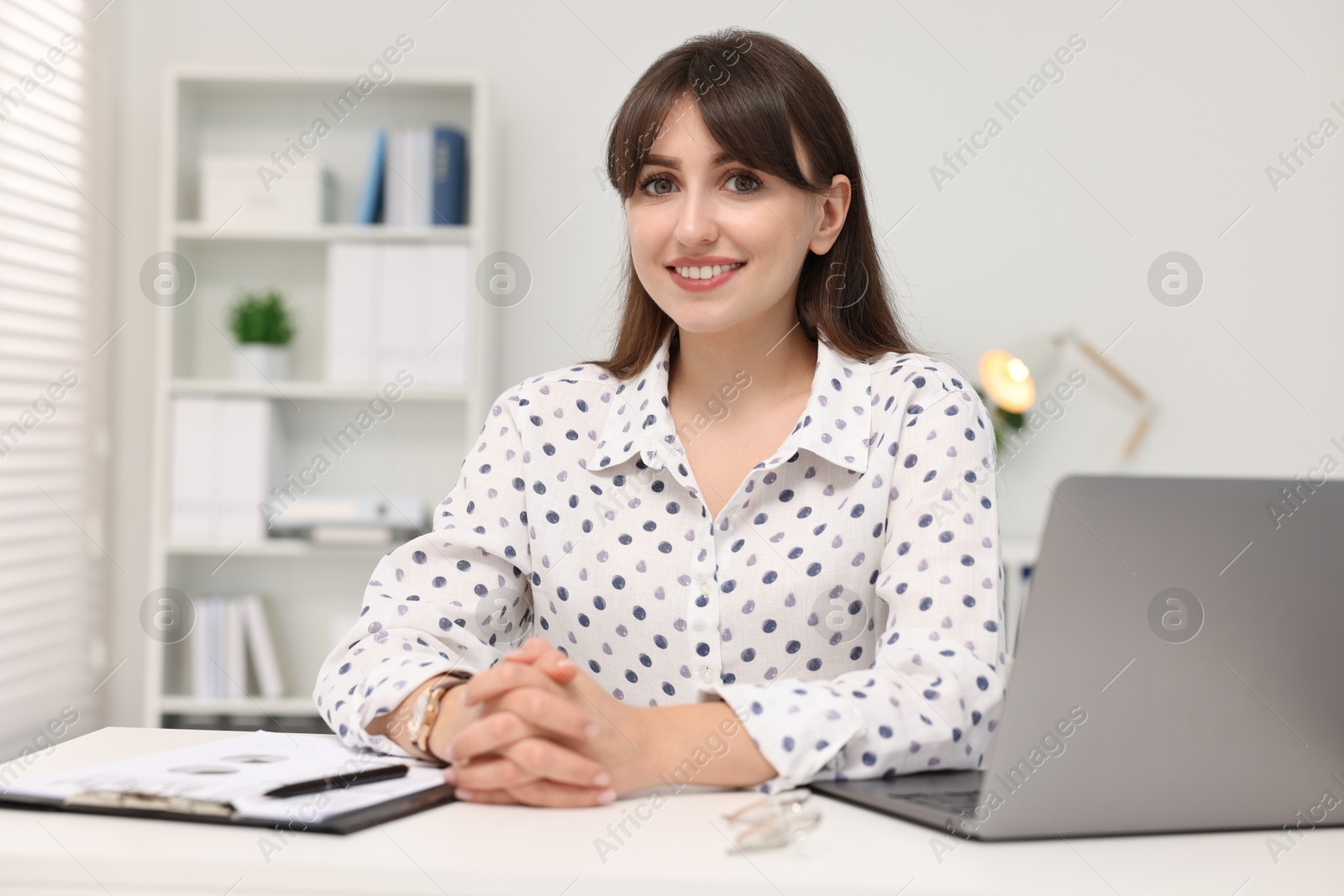 Photo of Portrait of smiling secretary at table in office