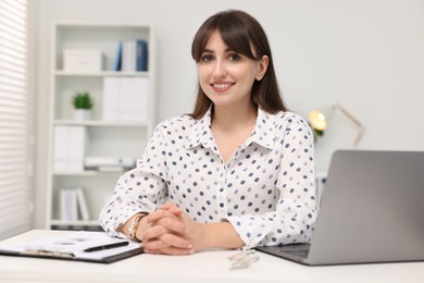 Portrait of smiling secretary at table in office