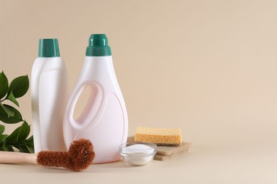 Bottles of cleaning product, sponges, brush and baking soda on beige background. Space for text