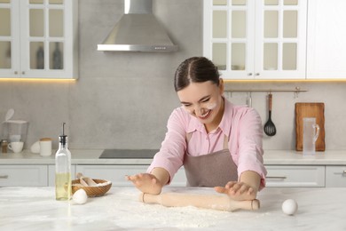 Photo of Happy woman with soiled face cooking at messy table in kitchen