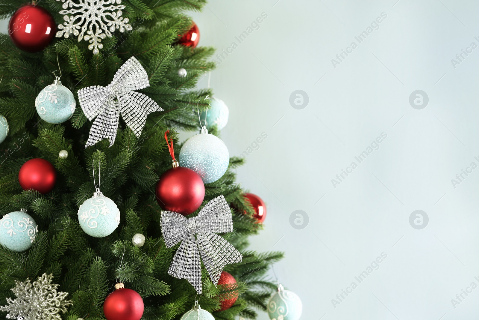 Photo of Beautiful Christmas tree with decor against light grey background. Space for text