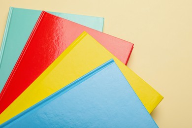 Photo of New colorful planners on beige background, top view