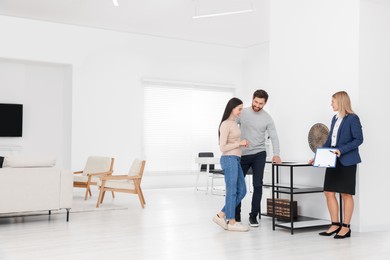 Photo of Real estate agent showing new apartment to couple