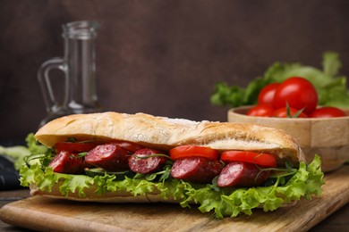 Photo of Delicious sandwich with sausages and vegetables on table, closeup. Space for text