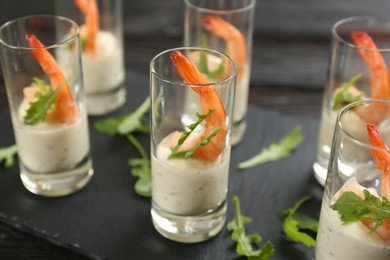 Photo of Delicious shrimp cocktail with tartar sauce served on table, closeup