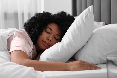 Beautiful young woman sleeping in soft bed at home