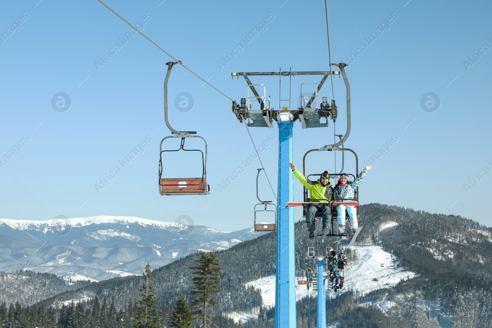 Photo of People using chairlift at mountain ski resort. Winter vacation