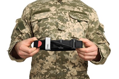 Photo of Soldier in military uniform holding medical tourniquet on white background, closeup