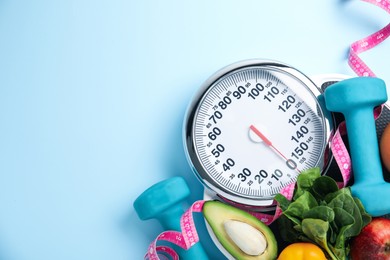 Photo of Flat lay composition with scales and healthy food on light blue background, space for text