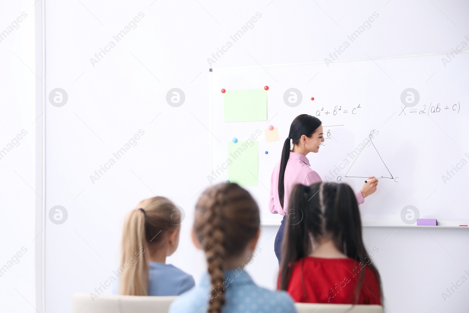 Photo of Young teacher and students in modern classroom