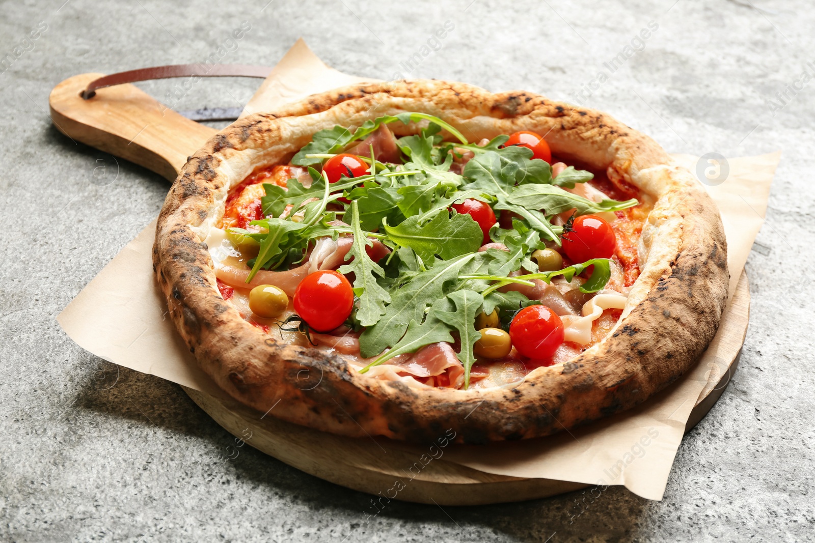 Photo of Tasty pizza with meat and arugula on grey table