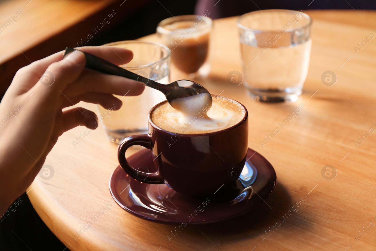 Photo of Woman with aromatic coffee at table in cafe, closeup