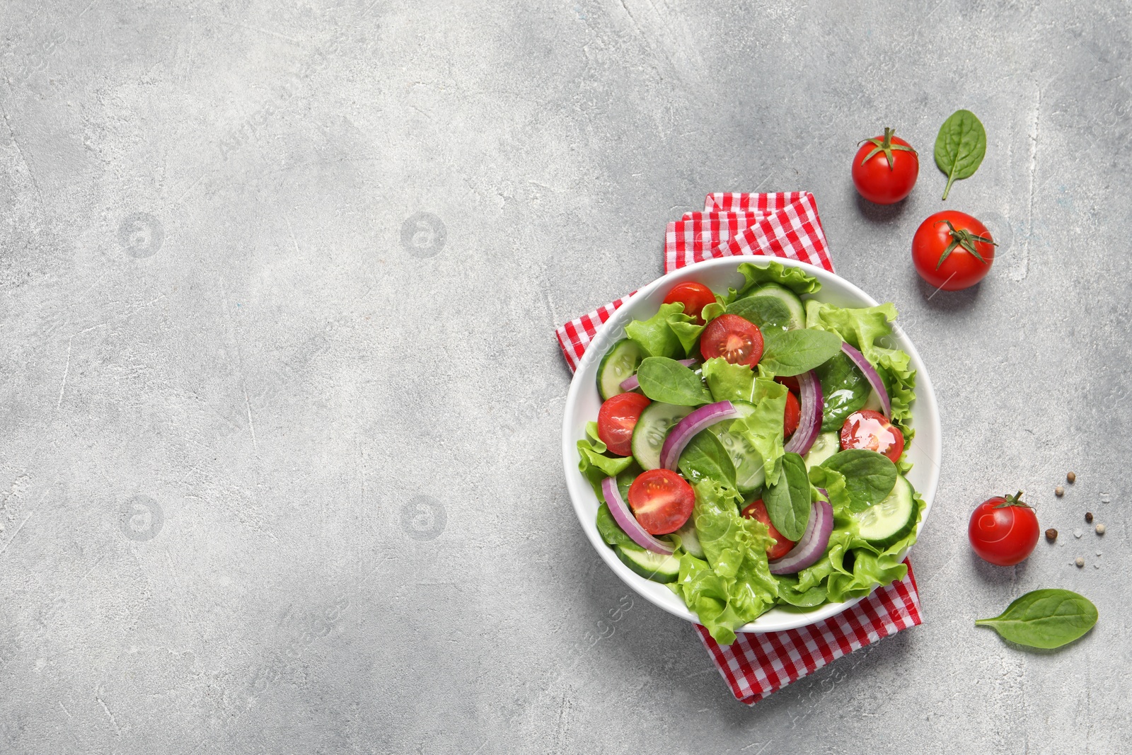 Photo of Delicious vegetable salad on light grey table, flat lay. Space for text