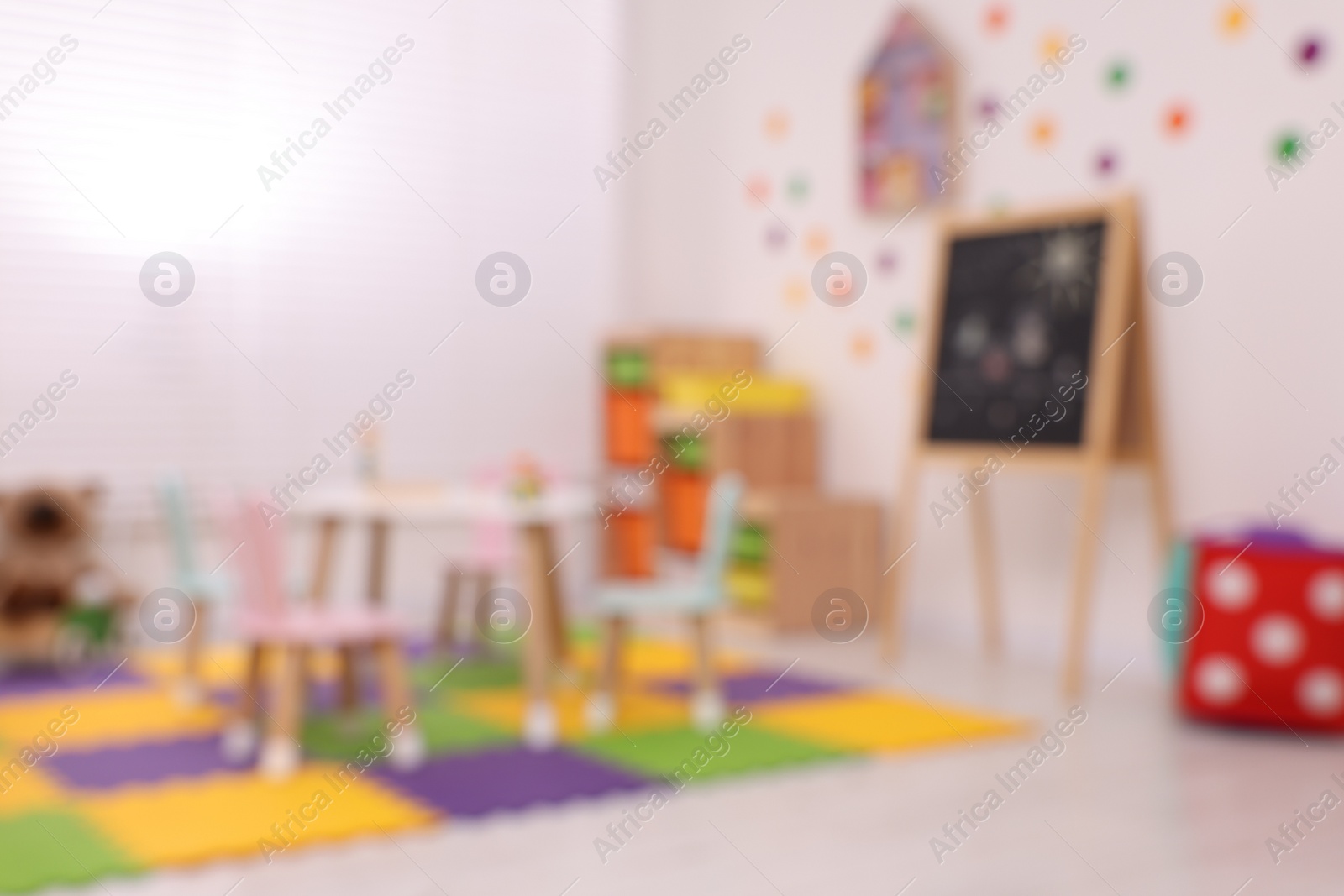 Photo of Stylish kindergarten interior with toys and modern furniture, blurred view