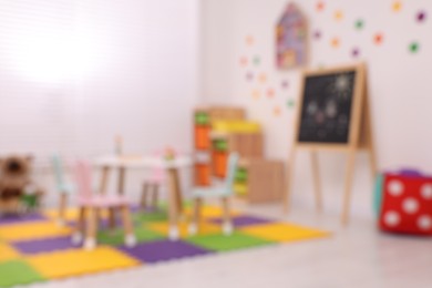 Stylish kindergarten interior with toys and modern furniture, blurred view