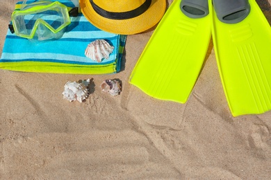 Photo of Set of different beach accessories on sand, above view. Space for text