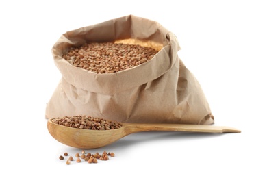 Paper bag and spoon with raw buckwheat on white background. Healthy grains and cereals