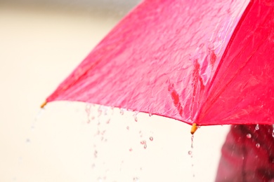 Photo of Bright color umbrella under rain outdoors, closeup