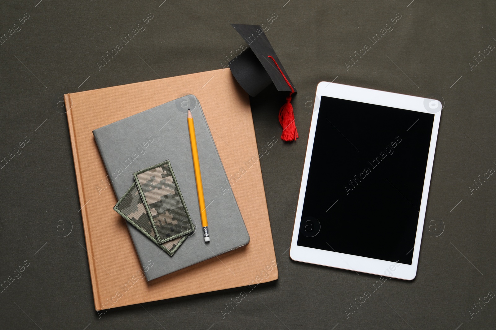 Photo of Flat lay composition with tablet and patches on dark background. Military education