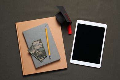 Flat lay composition with tablet and patches on dark background. Military education