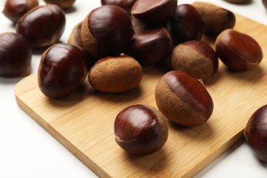 Sweet fresh edible chestnuts on white table, closeup