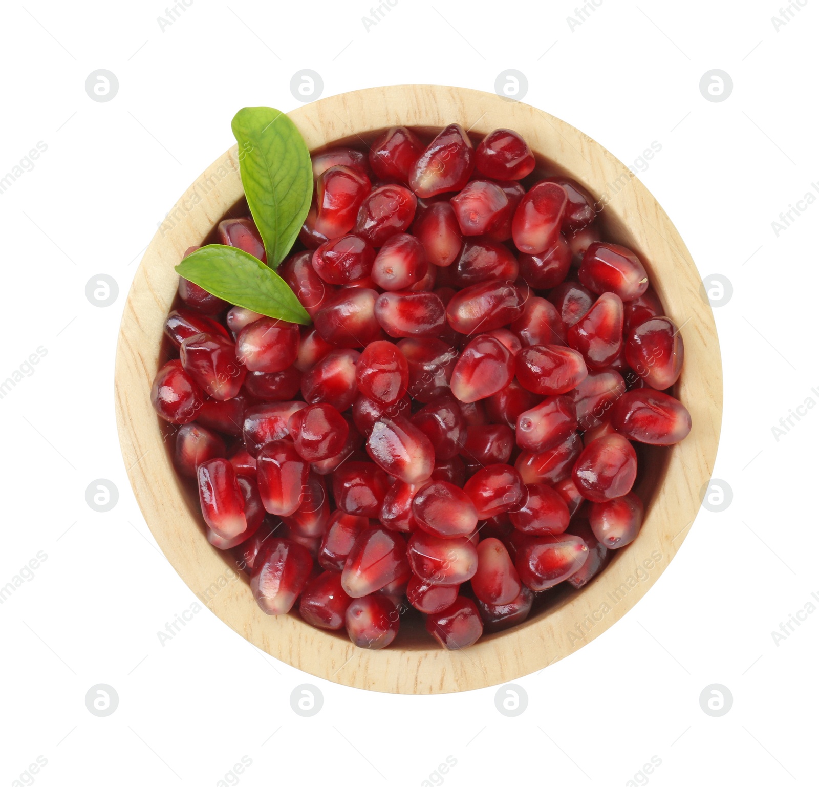 Photo of Ripe juicy pomegranate grains and leaves in wooden bowl isolated on white, top view