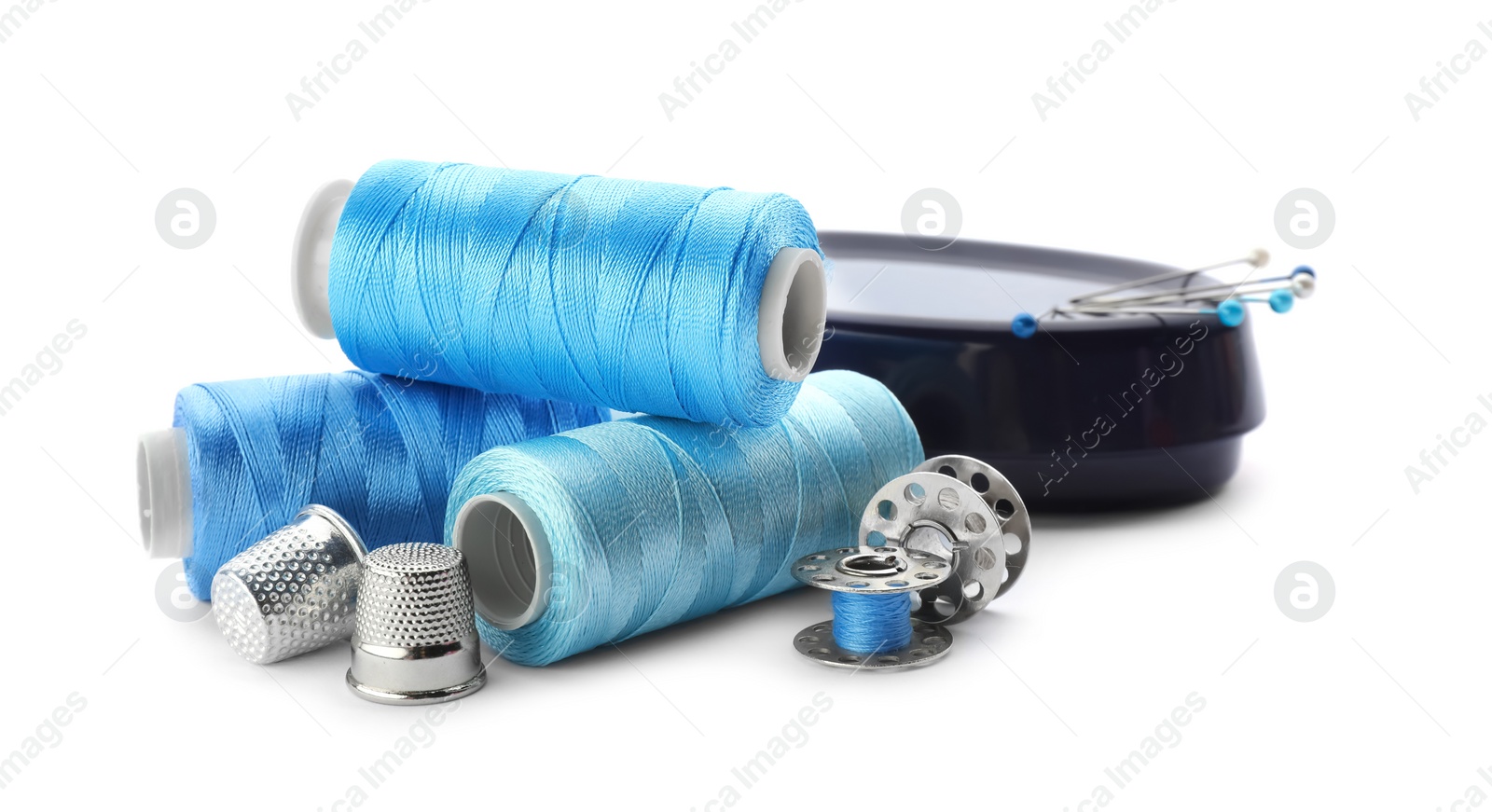 Photo of Color threads and sewing accessories on white background